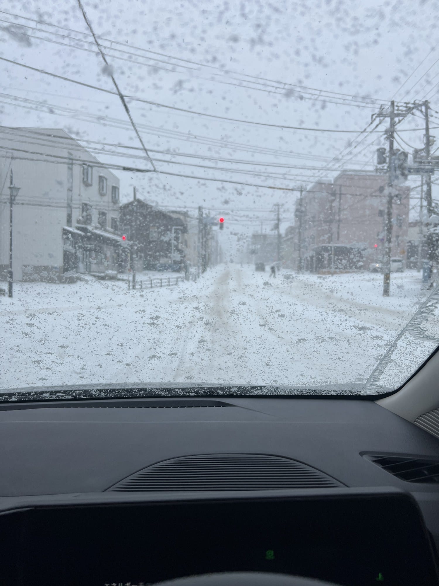 Snow-covered road to Kiroro seen through a windscreen during a December storm