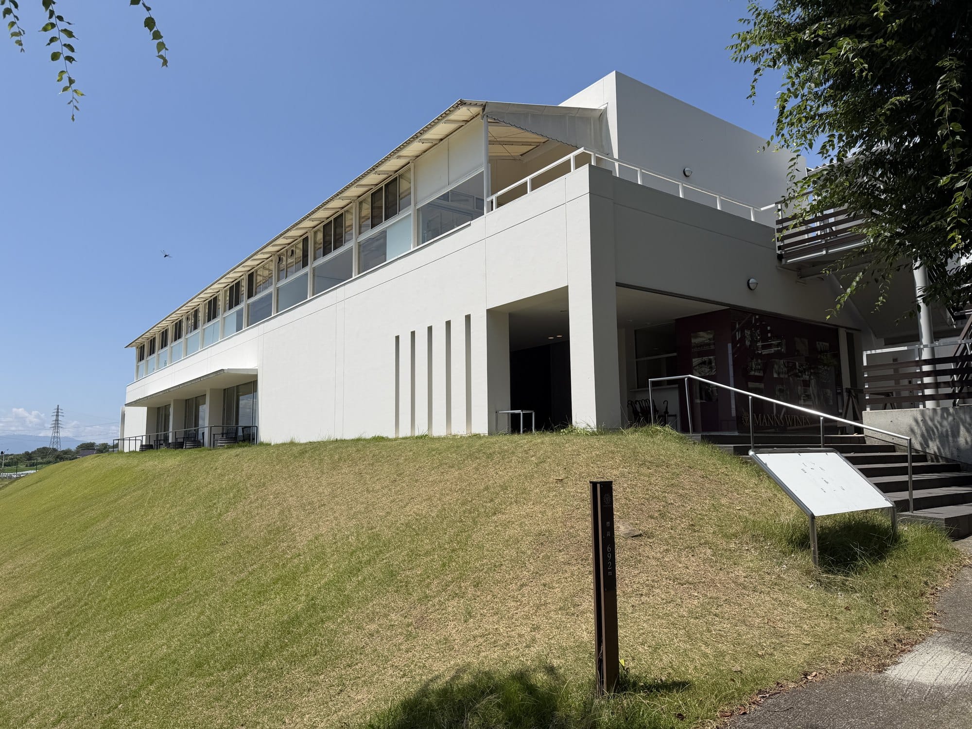 The Mannns Wines winery at Komoro in Nagano, a white modern building on a grassy slope