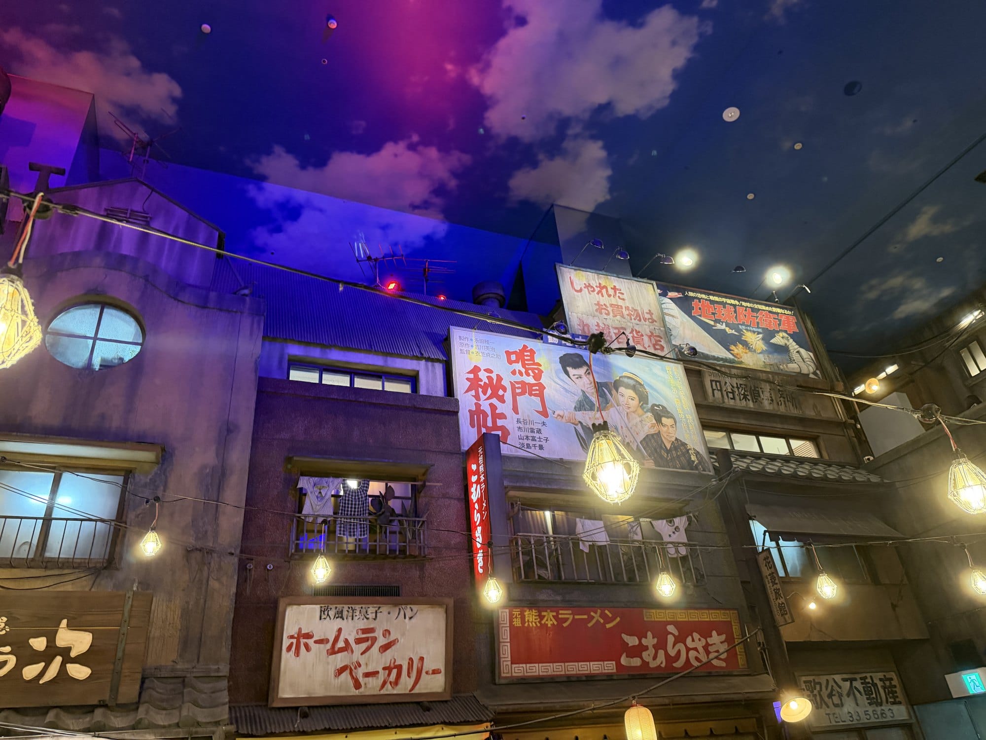 Shopfront of Komurasaki, the Kumamoto ramen branch, beneath painted 1950s film advertisements