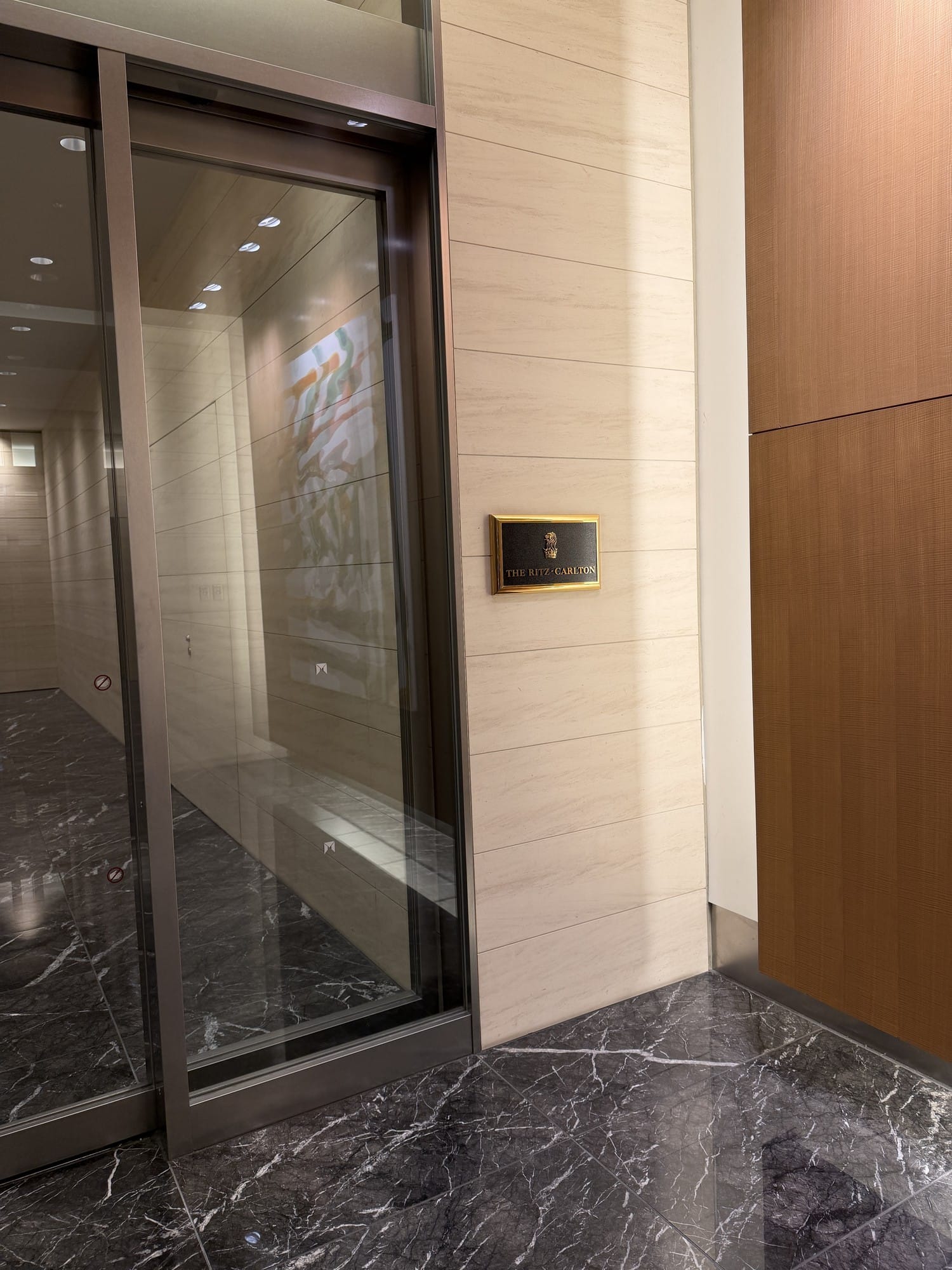 Brass Ritz-Carlton plaque beside a glass entrance inside Tokyo Midtown