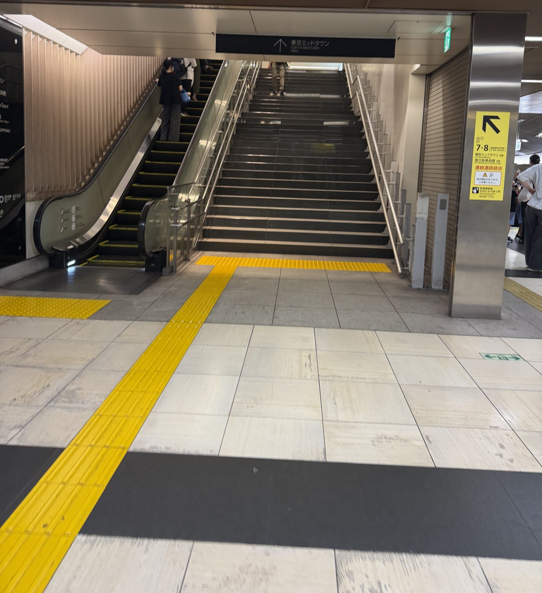 Escalator and stairs up to Exits 7 and 8 at Roppongi Station, signed for Tokyo Midtown