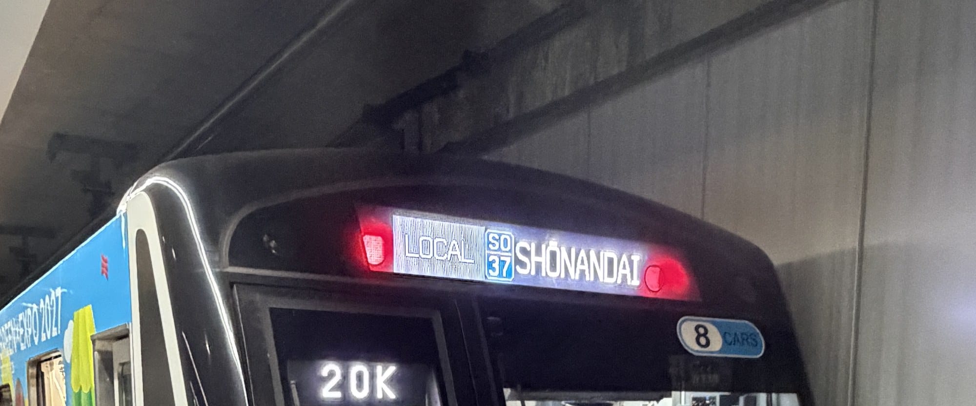 The front destination display of a GREEN×EXPO 2027 wrapped Tokyu train at Shin-Yokohama reading LOCAL, SO37, SHONANDAI, with an 8 CARS marker