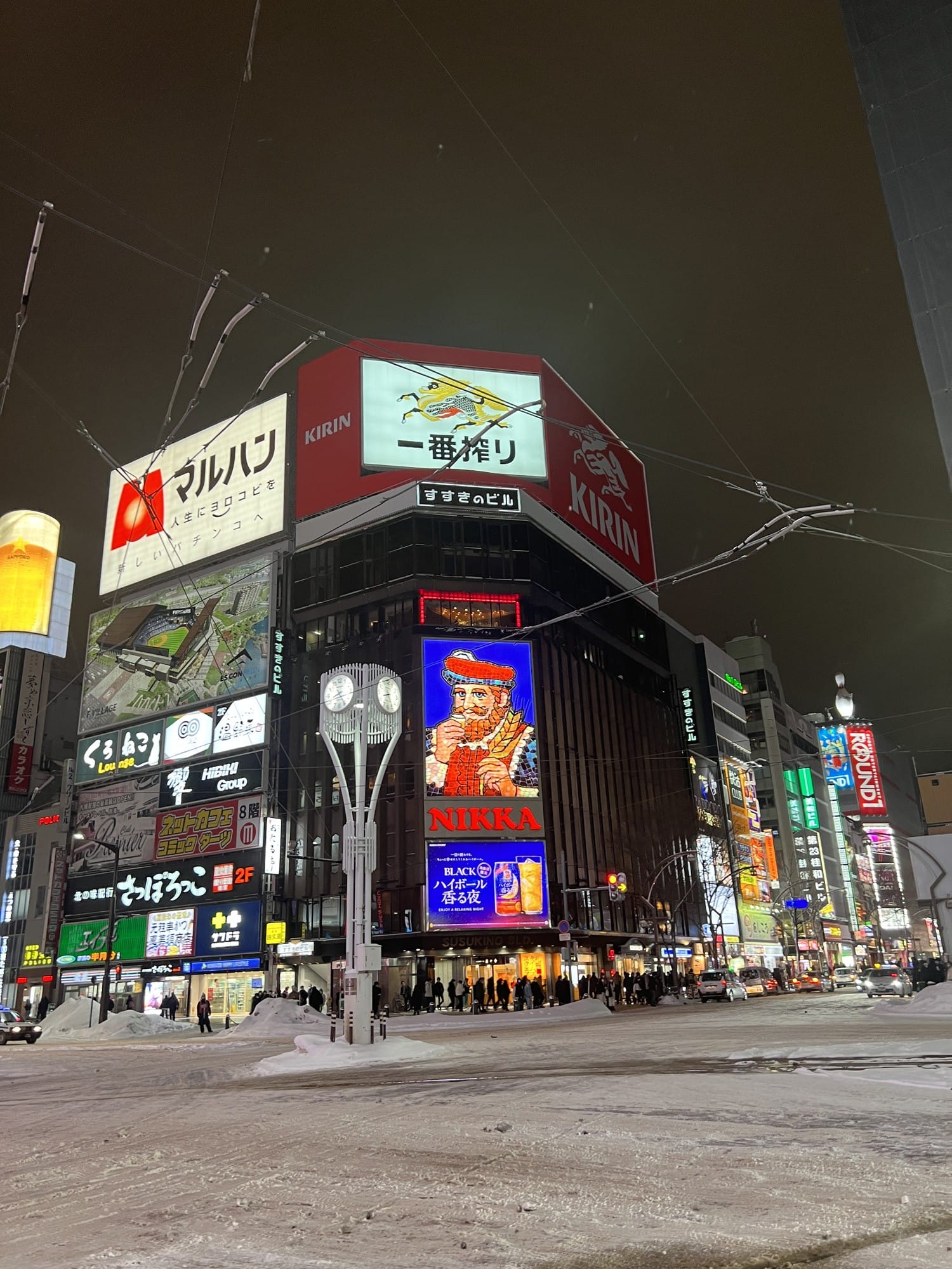 The illuminated NIKKA sign on Susukino Building at the Susukino crossing on a snowy winter night