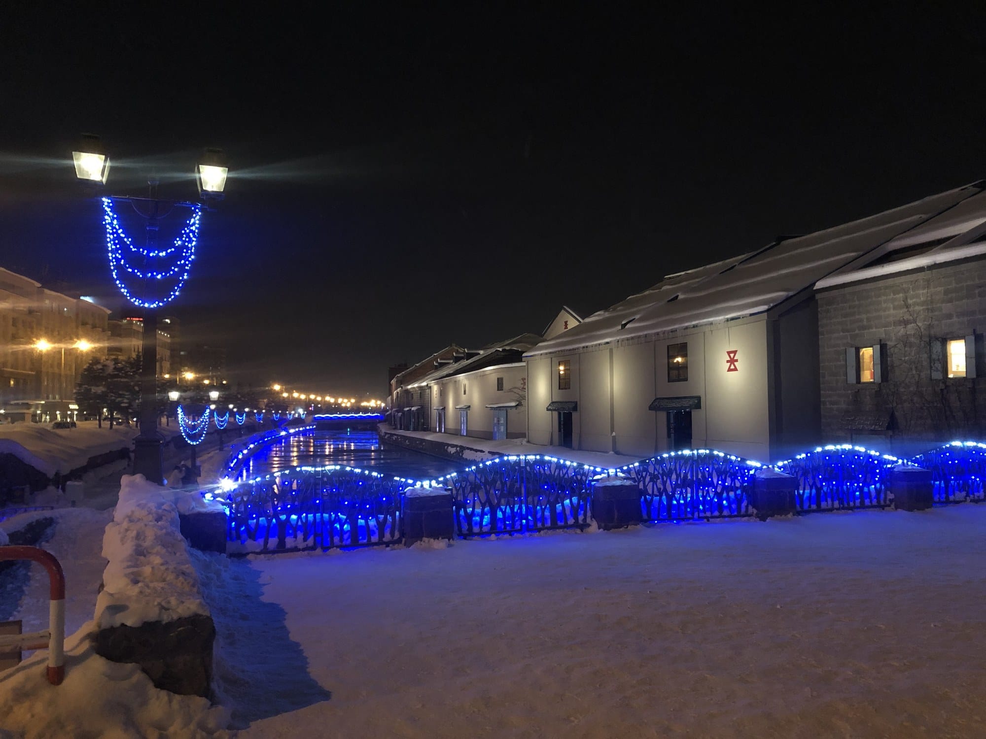 The Otaru Canal lined with blue lights, snow banked along the towpath