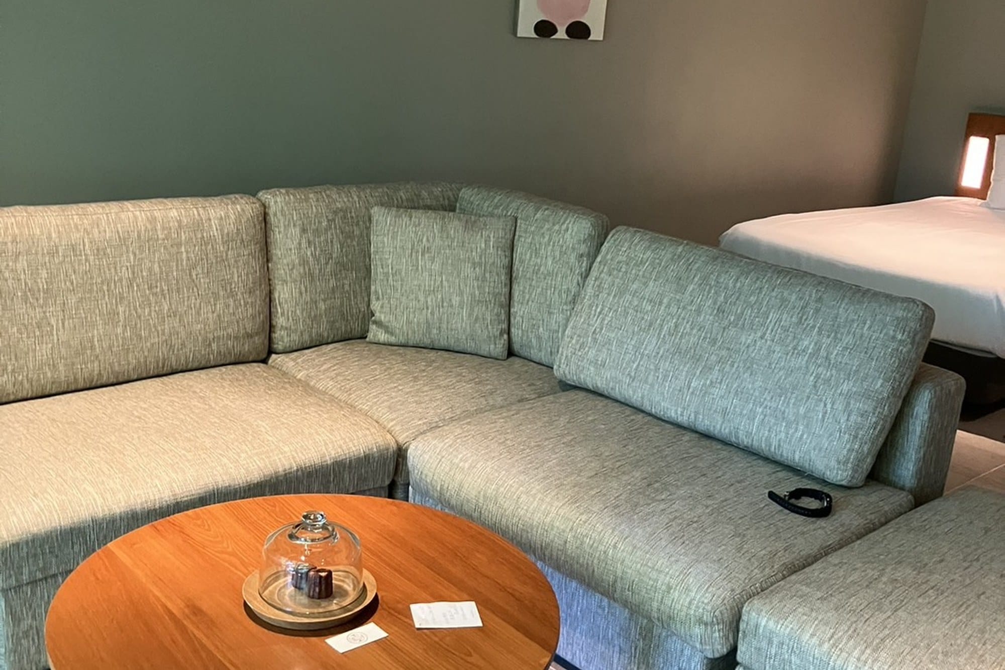 A Yufuin ryokan sitting room with a pale sofa, low wooden table and garden light through the window