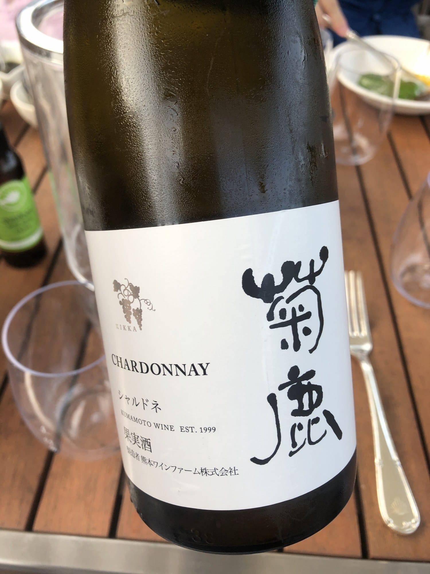 Chilled bottle of Kikuka Chardonnay from Kumamoto Wine Farm on an outdoor table