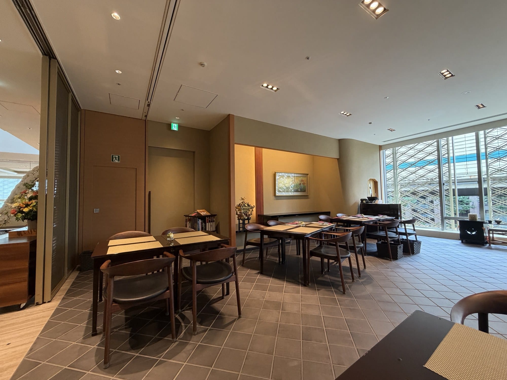 Bentwood armchairs and a table set with a placemat inside Tea Lounge Kafu, with the kumiko lattice window visible in the background.