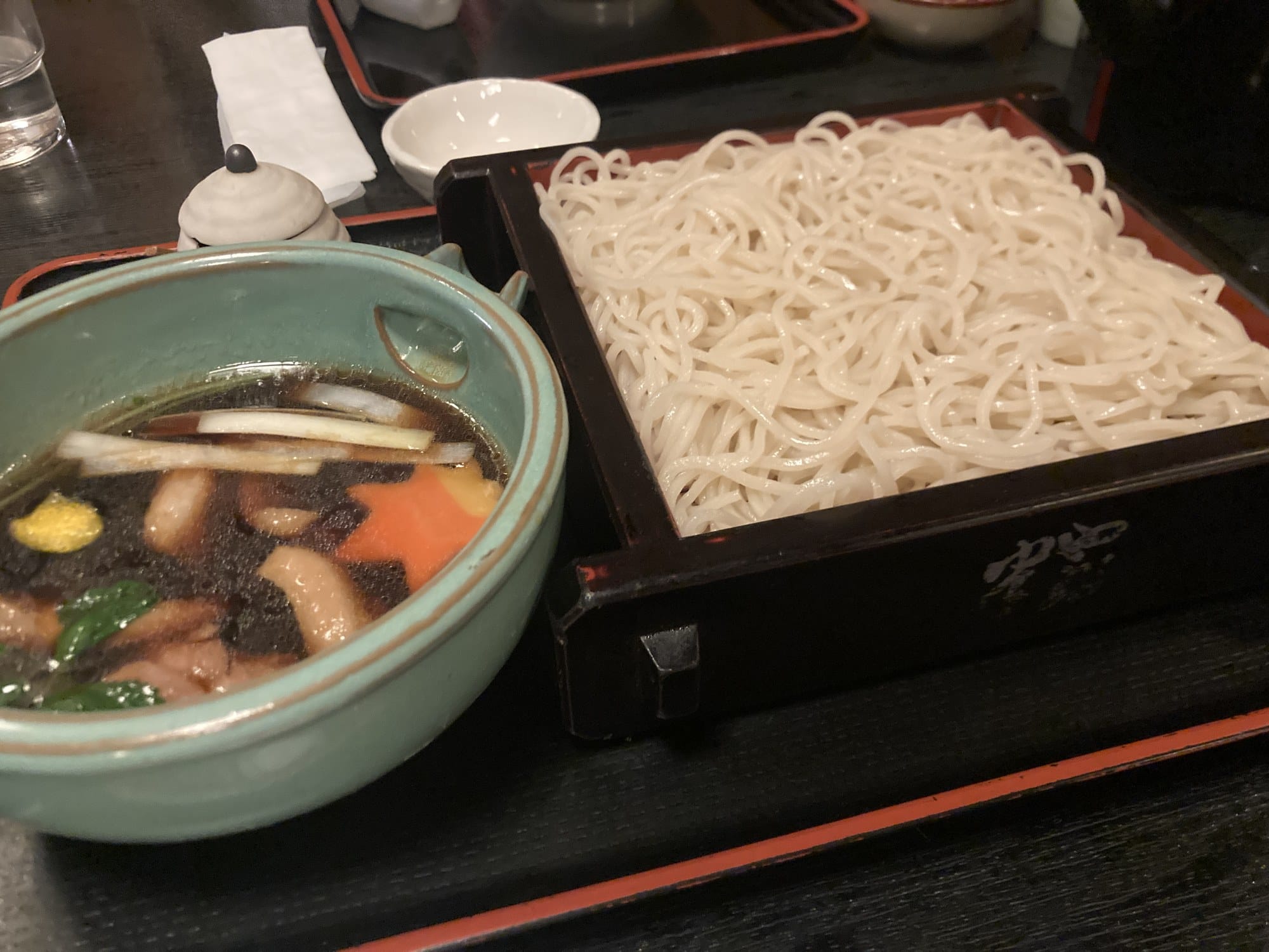 Kamo seiro — sliced duck in hot dipping broth beside a basket of cold soba
