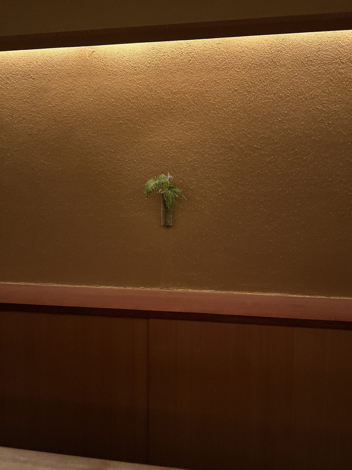 Quiet ryokan alcove with a single ikebana arrangement, Kyoto