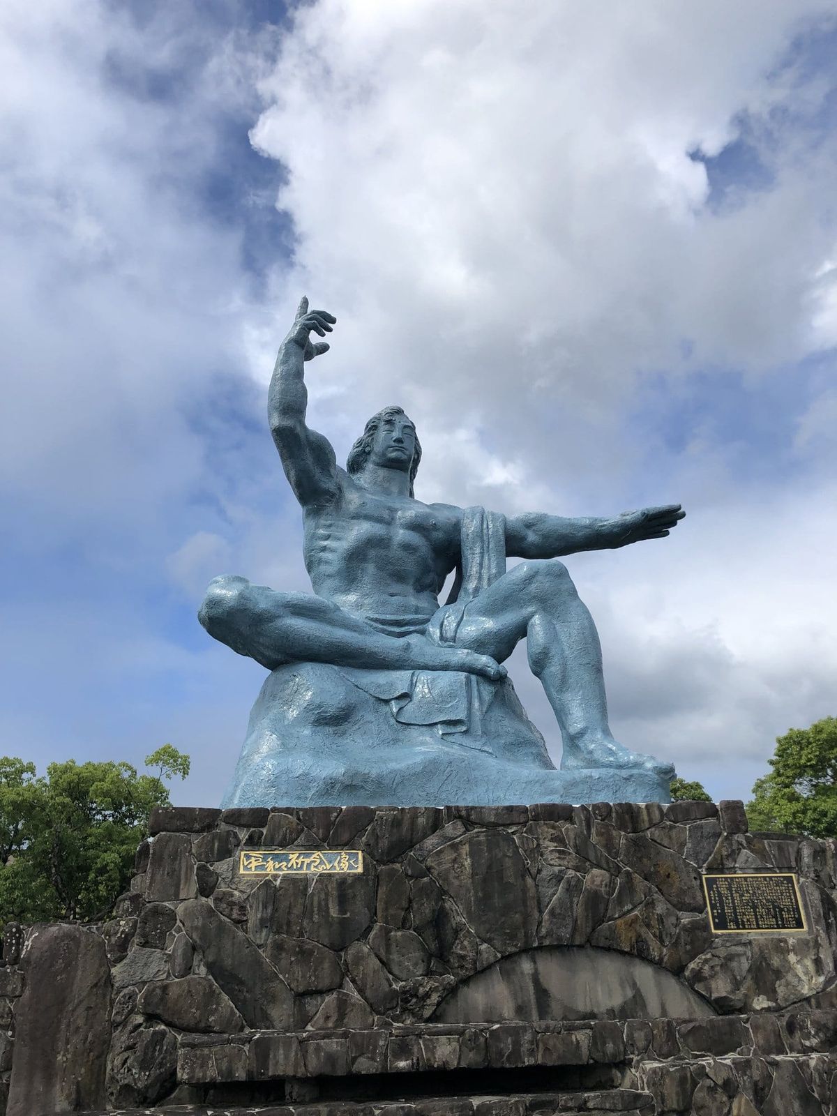 Peace Statue at Nagasaki Peace Park under a blue sky