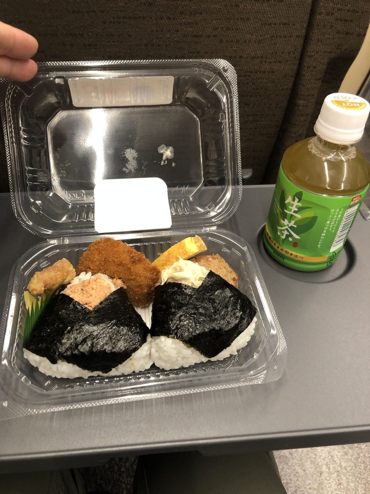 Bento and tea on the tray table of a reserved u-Seat car on the Rapid Airport train