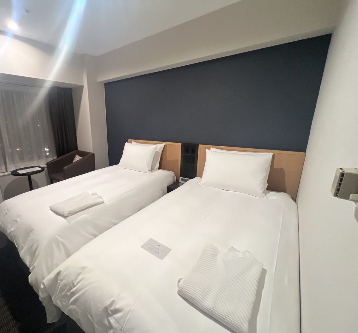 Twin beds against a navy accent wall in a room at ANA Crowne Plaza Sapporo