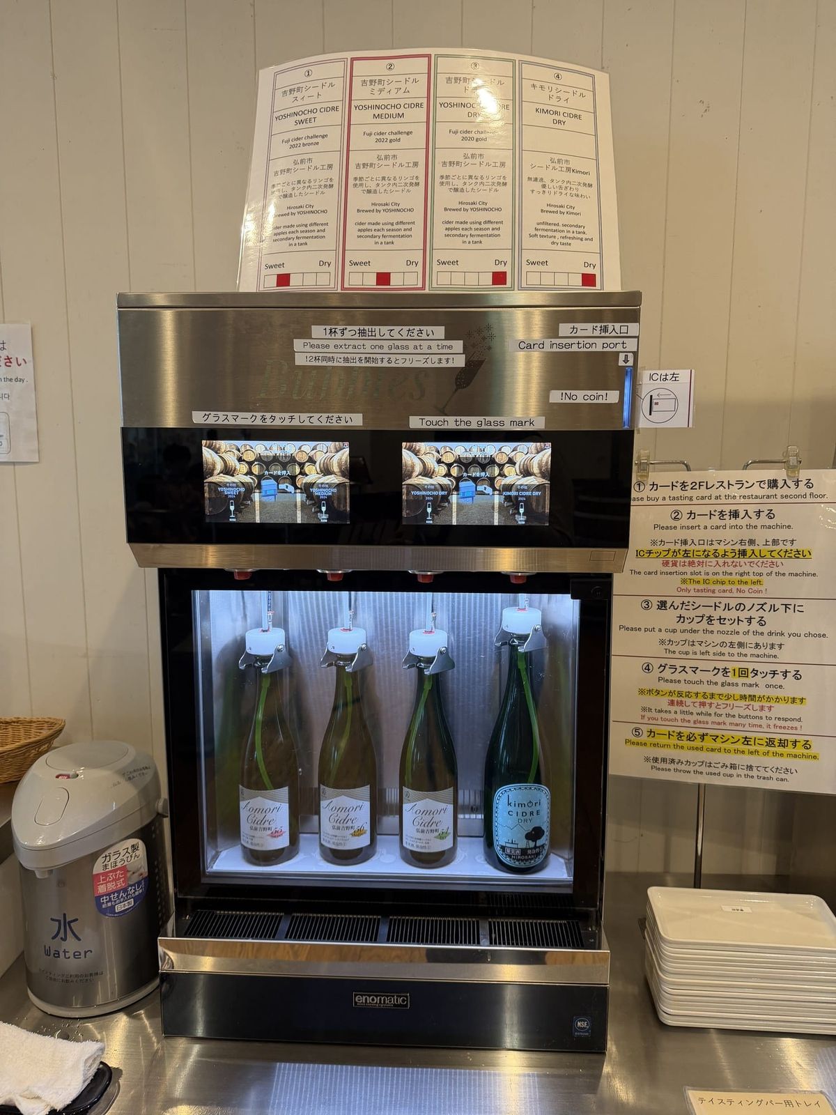 Self-serve cider tasting machine at A-FACTORY in Aomori, with the five operating steps printed in English beside it