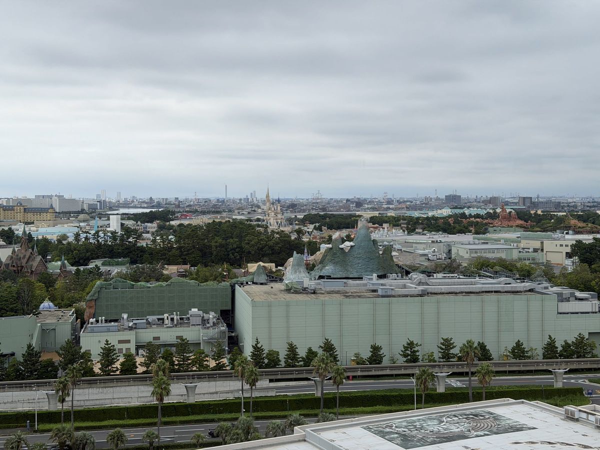 Daylight view over Tokyo Disney Resort from a hotel room window with Cinderella Castle in the distance