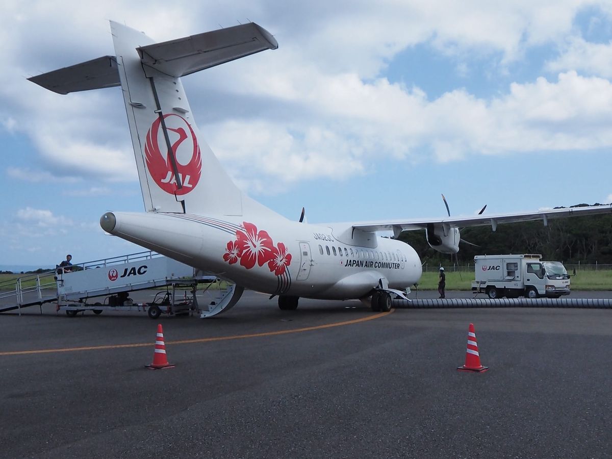 A Japan Air Commuter ATR 42 in hibiscus livery on an island apron