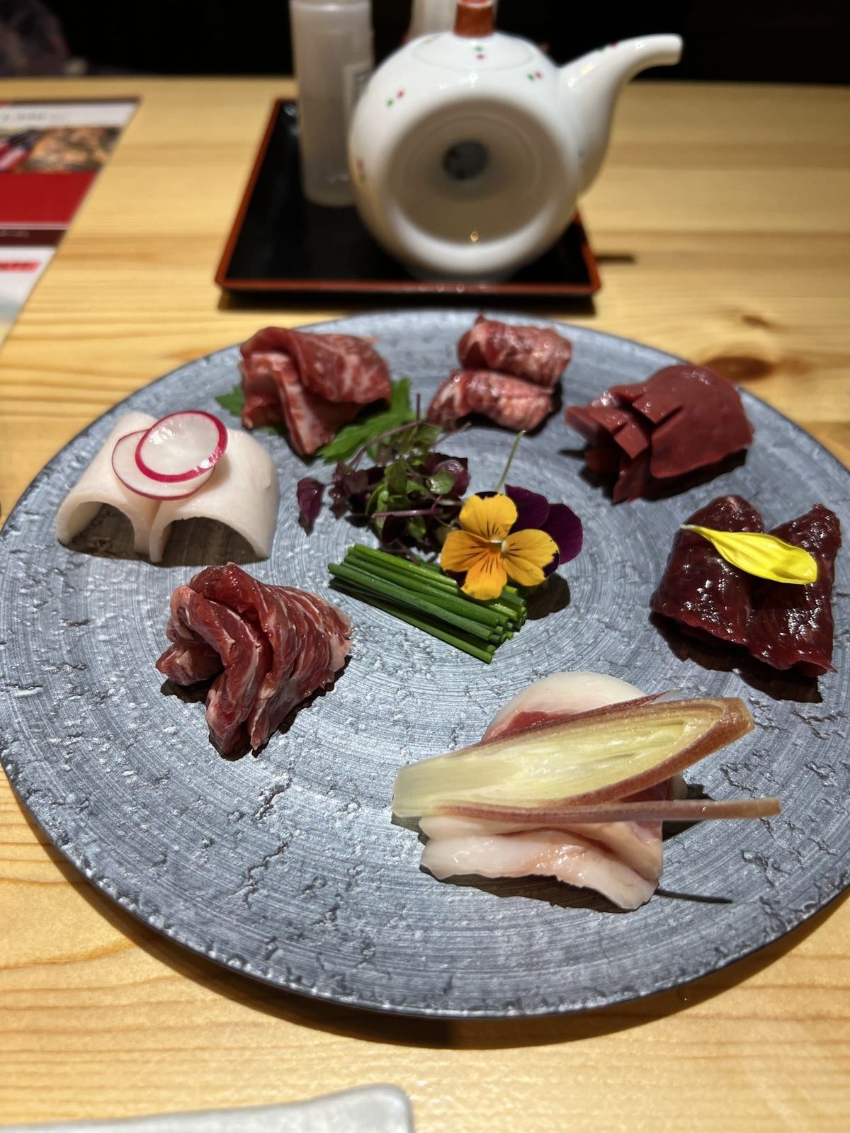 Basashi horse sashimi platter with lean and marbled cuts on a gray plate