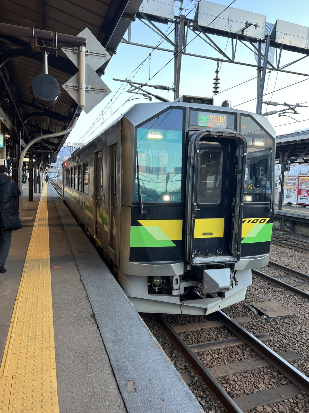 An H100 diesel railcar waiting at the platform, the train type you change to west of Otaru