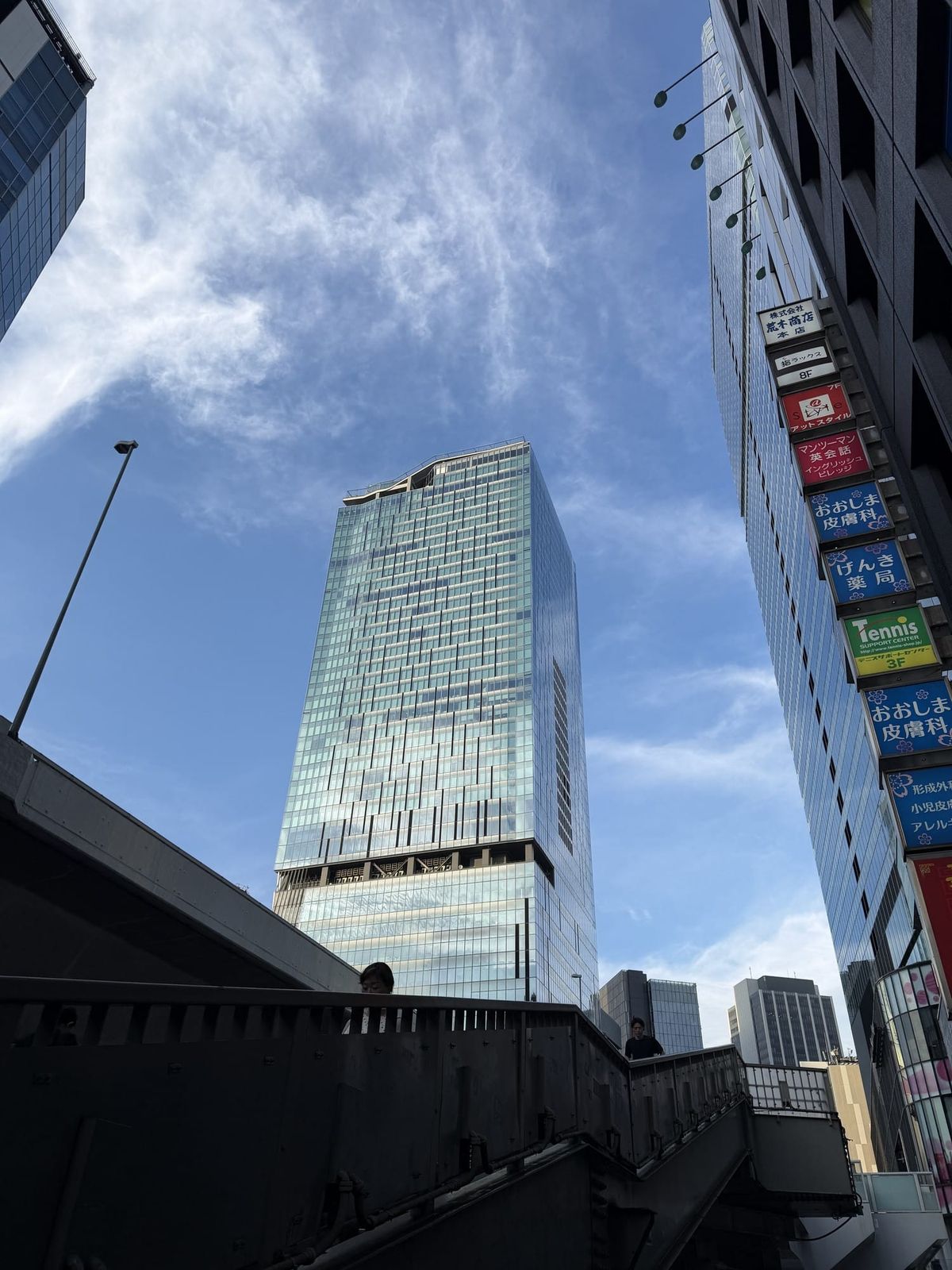 Shibuya Scramble Square seen from street level against a blue sky