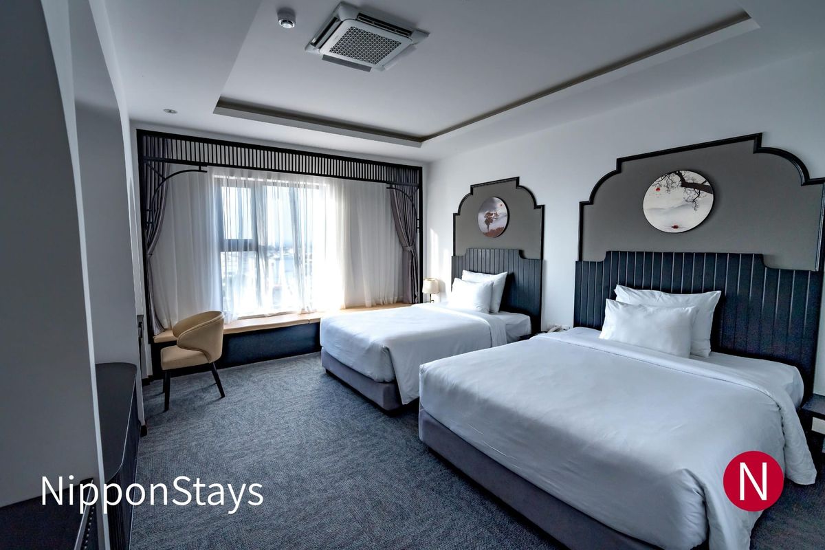 A modern hotel room with two beds side by side