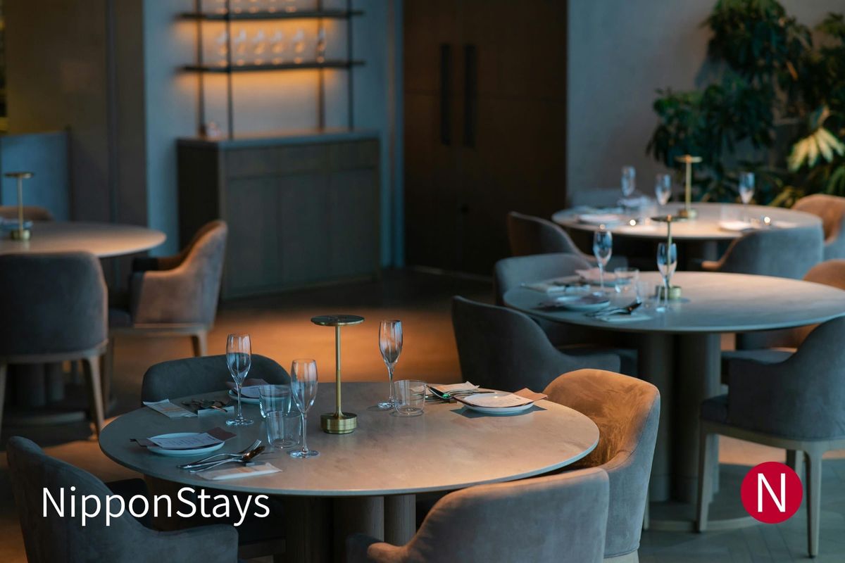 An elegant restaurant dining room set for dinner in low evening light