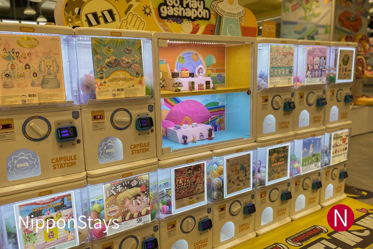 A wall of capsule-toy vending machines in a Japanese shopping arcade