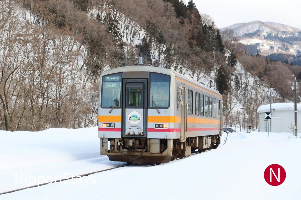 A local train crossing a snow-covered valley in Nagano