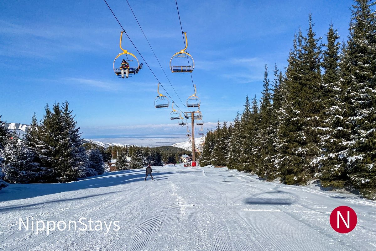 Chairlift over a groomed piste at a snow-covered ski resort