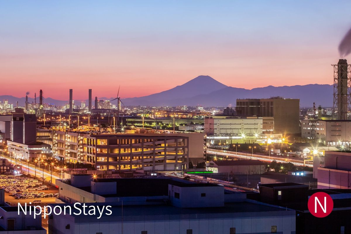 The Kawasaki industrial waterfront at dusk with Mount Fuji behind it