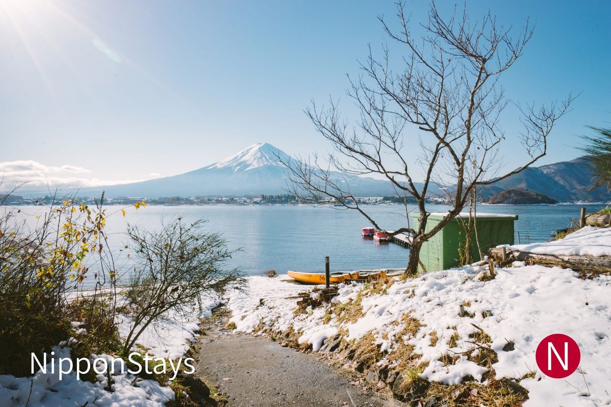 Mount Fuji seen across Lake Kawaguchi with snow along the shore