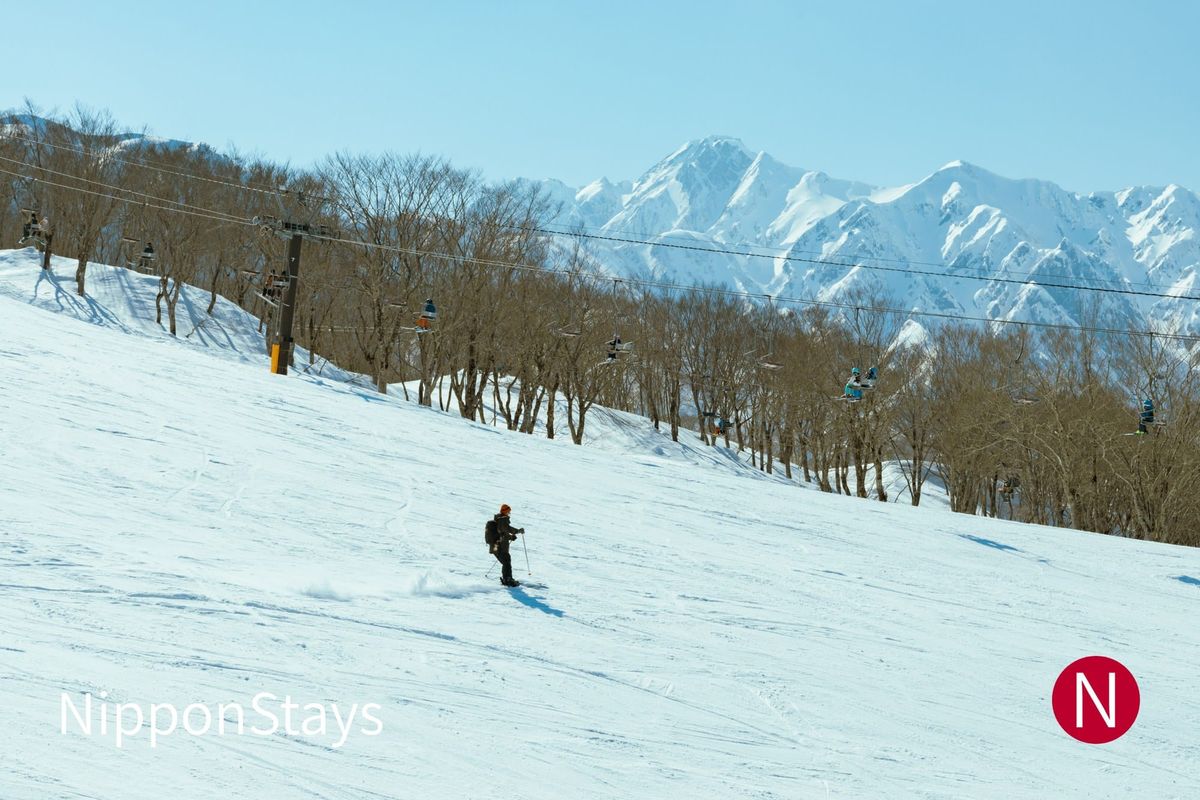 A groomed slope at Hakuba with the snow-covered Northern Alps behind