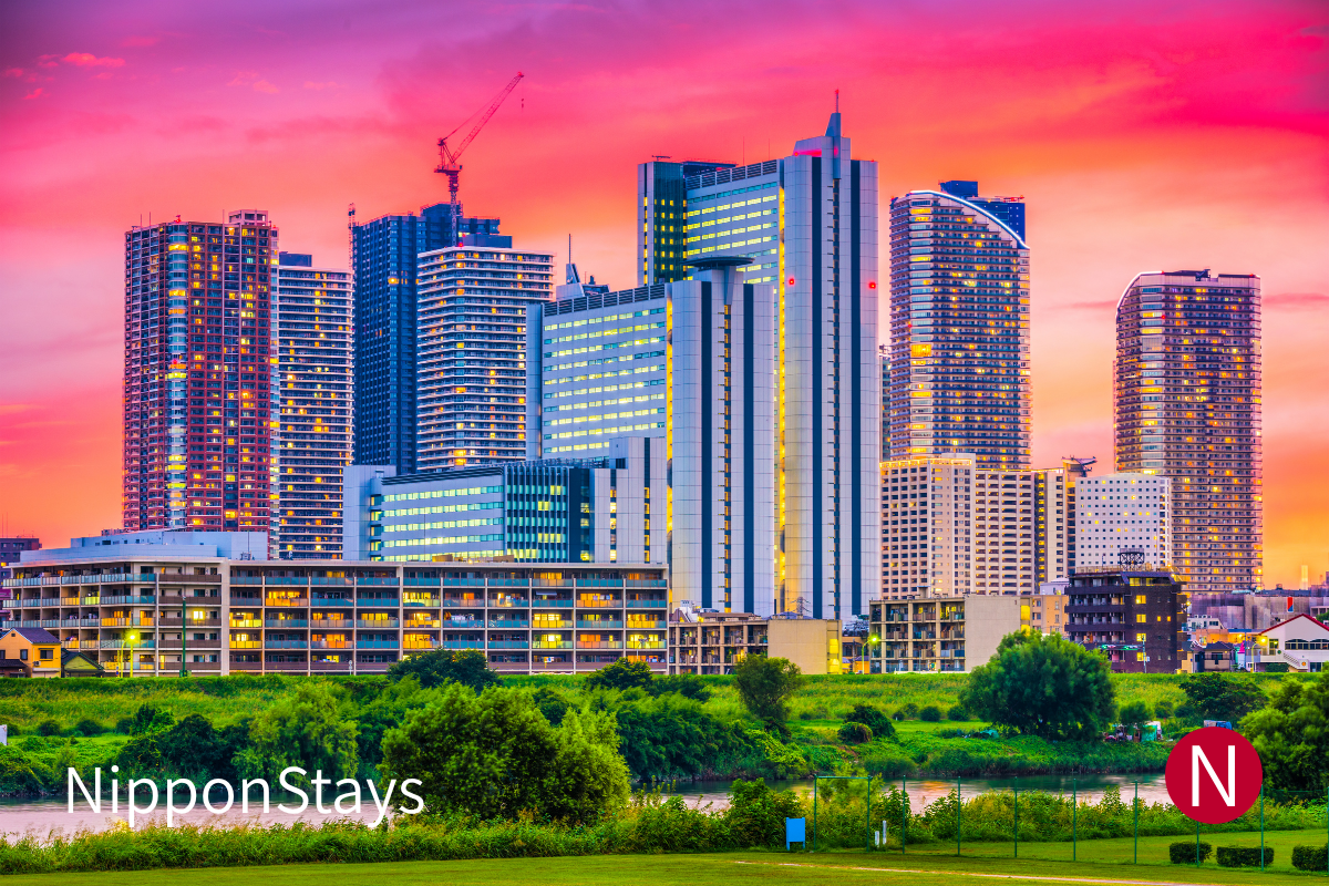 Kawasaki skyline at dusk with modern high-rise buildings and an open sky.