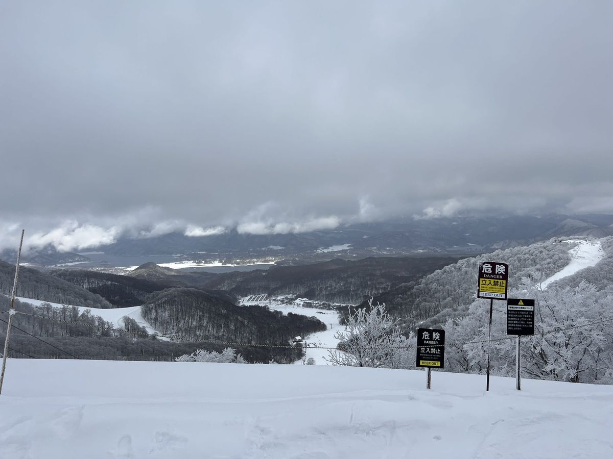 The managed-area boundary rope and DANGER / KEEP OUT signs on the summit ridge at Nekoma Mountain, looking north over Lake Hi