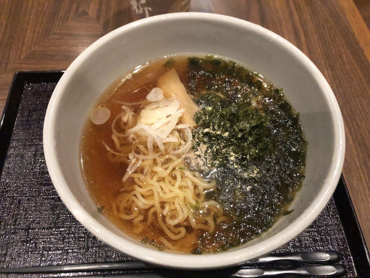 A bowl of free late-night shoyu ramen (yonaki soba) with sliced spring onion and seaweed at Dormy Inn Premium Otaru