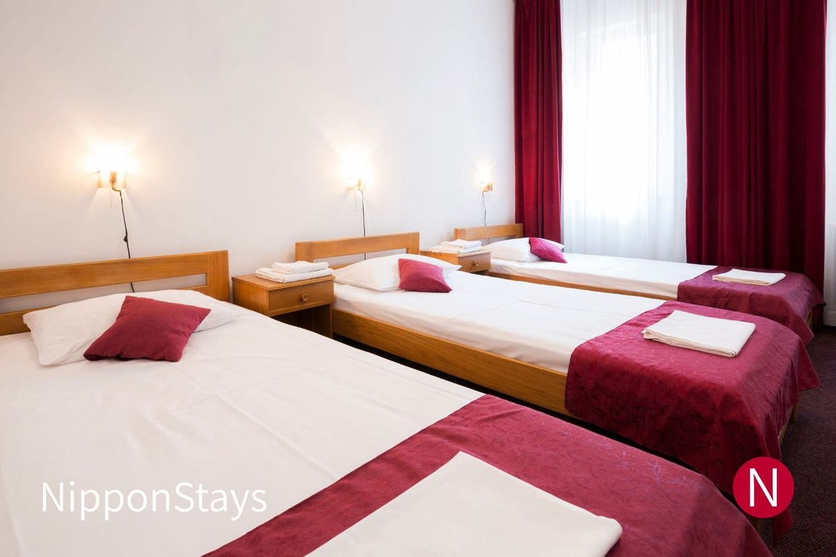 Three single beds of the same height in a row in a hotel room