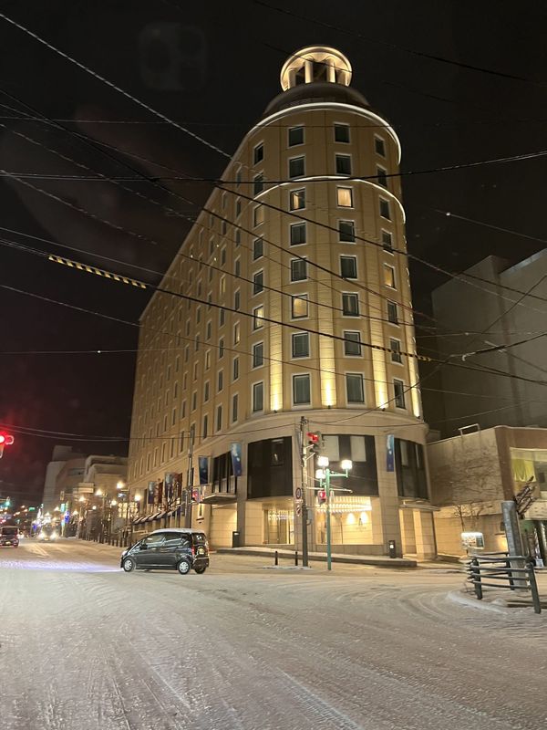 Authent Hotel Otaru tower lit at night on a snow-covered street