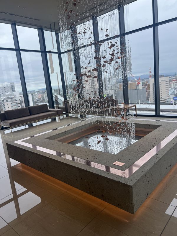 Lobby lounge at Candeo Hotels Utsunomiya with a stone-framed installation and city view