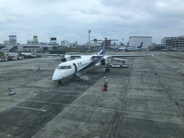 An ANA turboprop on the apron at Osaka Itami Airport with ground crew