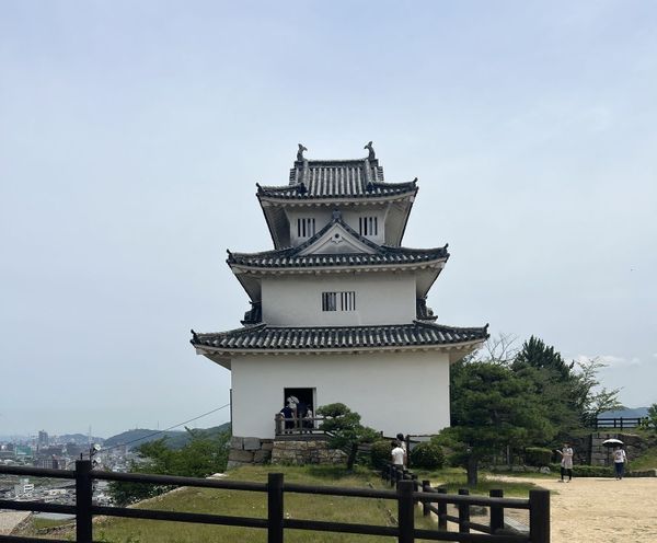 A preserved Edo-period castle tower in Kagawa Prefecture with white plaster walls and dark tiled roofs