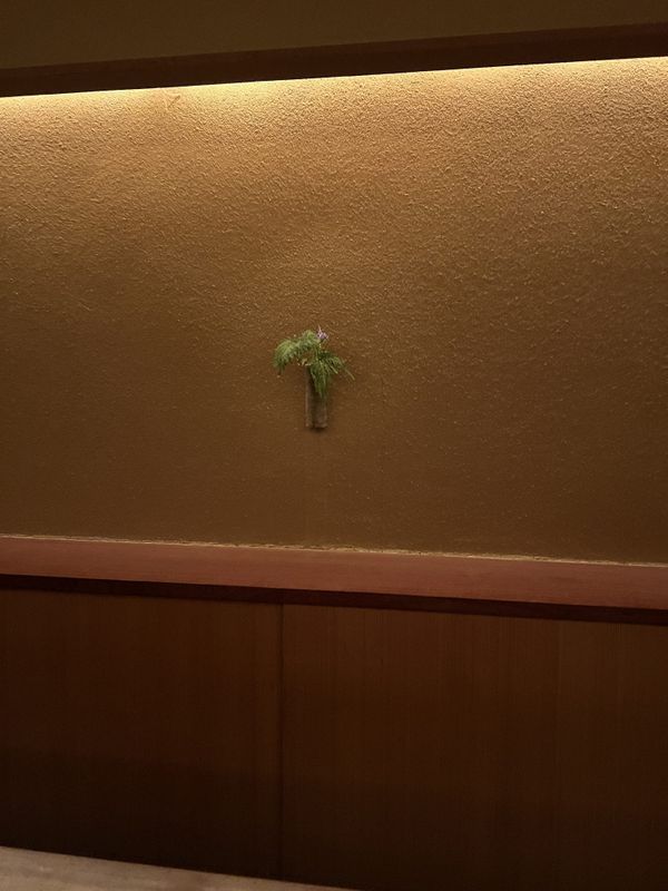 Quiet ryokan alcove with a single ikebana arrangement, Kyoto