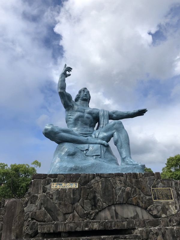 Peace Statue at Nagasaki Peace Park under a blue sky