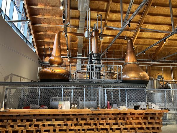 Copper pot stills under a timber roof at Niseko Distillery