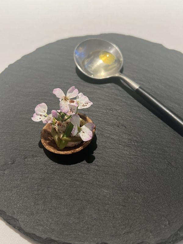 A flower-topped amuse-bouche served on slate at Otowa Restaurant in Utsunomiya