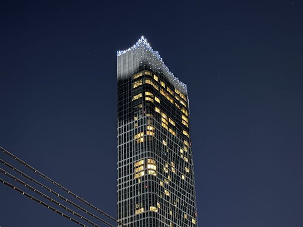 Tokyu Kabukicho Tower illuminated at night above the Seibu-Shinjuku railway tracks