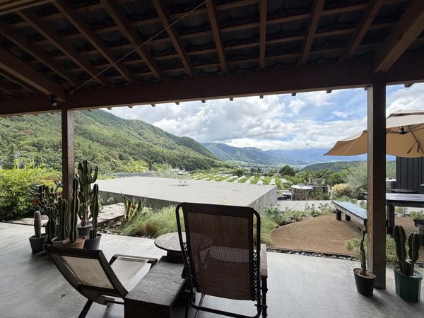 The view from the terrace at 98WINEs in Yamanashi, looking out under a deep eave across the Kofu basin to the mountains beyon