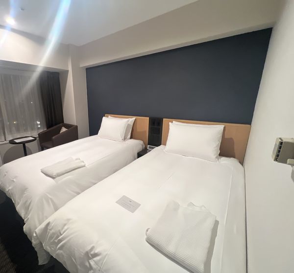 Twin beds against a navy accent wall in a room at ANA Crowne Plaza Sapporo
