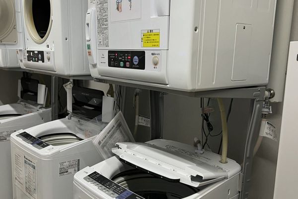 Stacked washers and dryers in a hotel's shared coin laundry in Japan