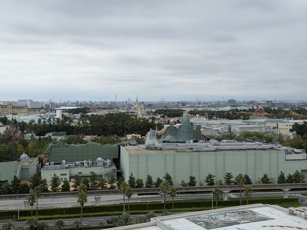 Daylight view over Tokyo Disney Resort from a hotel room window with Cinderella Castle in the distance