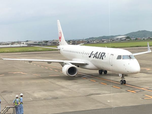 A J-AIR Embraer regional jet taxiing at a small Japanese airport
