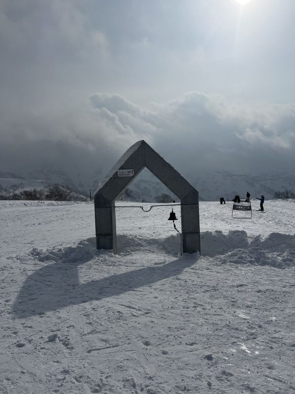 Stone gate at the top of Kiroro with a sign recording 580cm of snow for the 2025-26 season