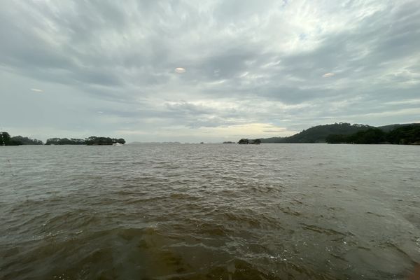 Matsushima Bay from water level, with pine-topped islands scattered across the water under a heavy grey sky